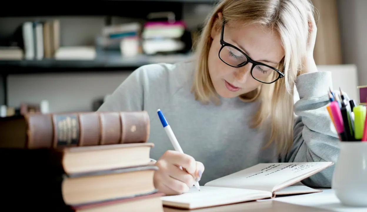 A person writing in an evening journal