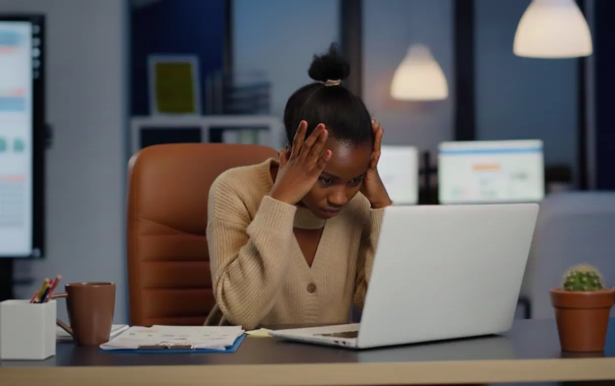 Людина пізно ввечері працює за ноутбуком у напрузі, коли кортизол ще високий