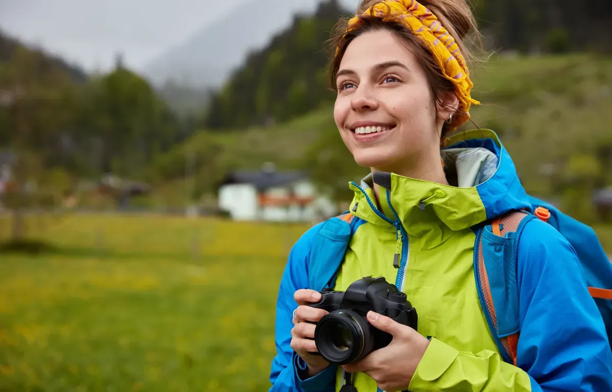 Жінка з фотоапаратом насолоджується прогулянкою на природі — хобі, що стабілізує емоції та підсилює серотонін.