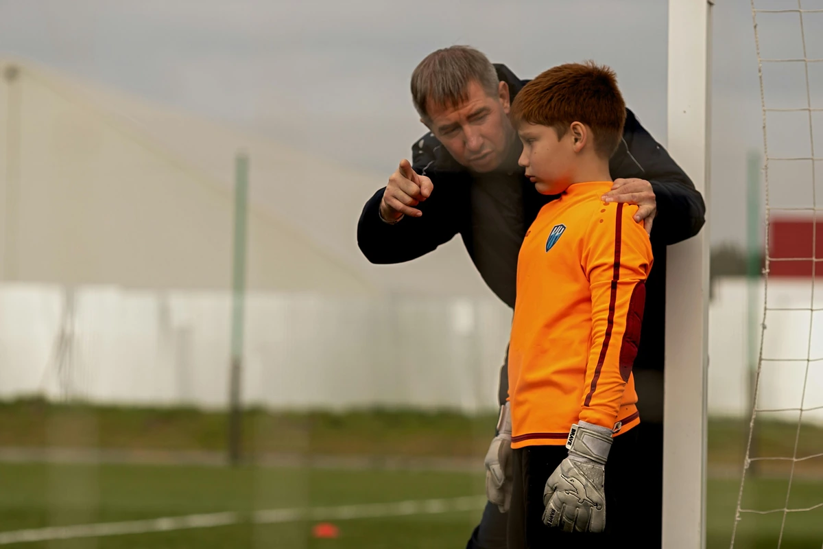 A former footballer father coaching his son as a goalkeeper. The child as a project