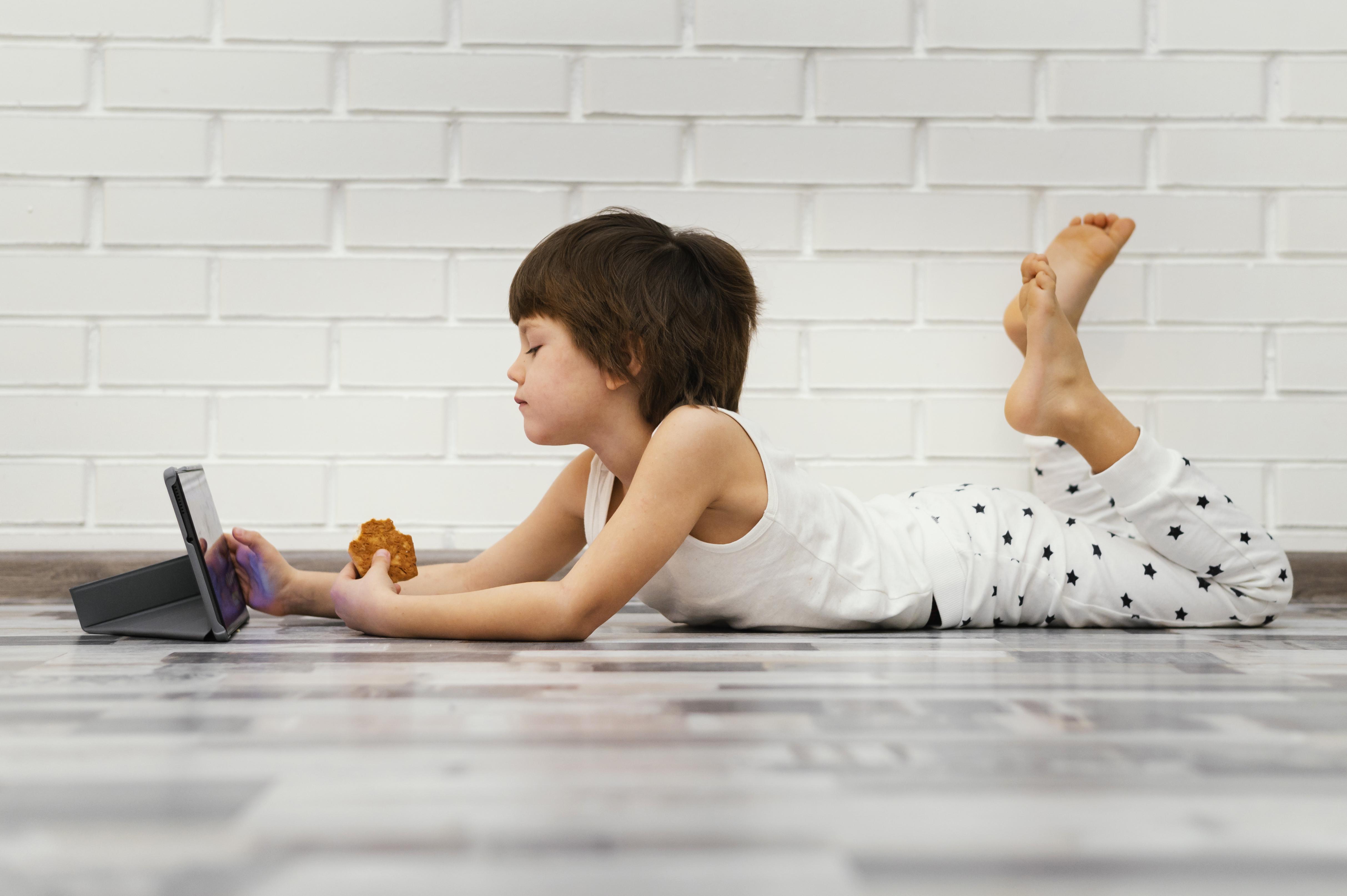 Dziecko z tabletem na podłodze - 5 markerów, kiedy ekran zastępuje uspokojenie, kontakt i żywe zainteresowanie