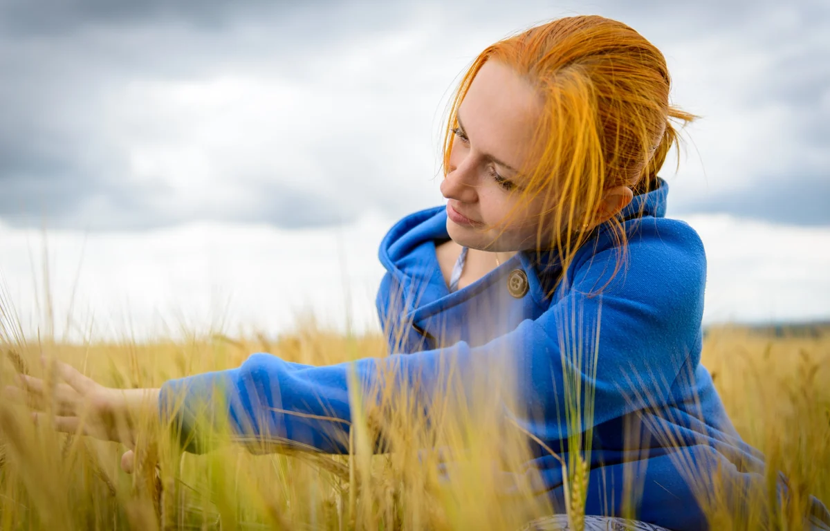 A quiet pause in travel - a woman in a field as an image of slow travel and recovery after overload